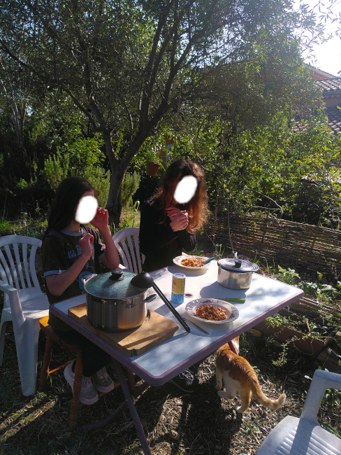 On mange à la table, dans le jardin